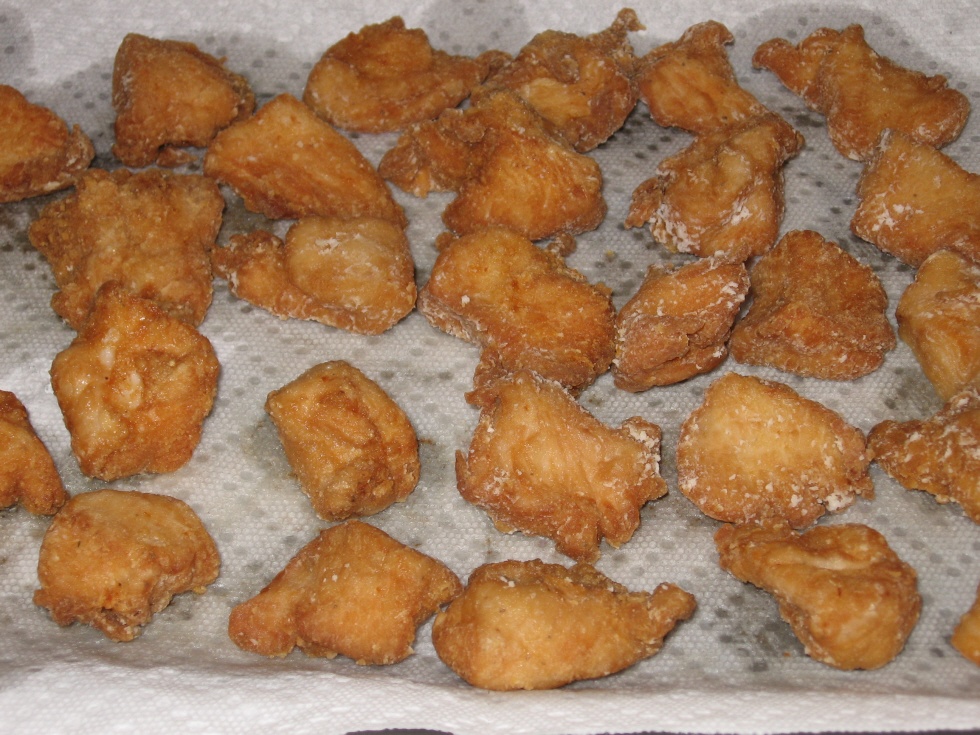 Click to enlarge - Browned chicken morsels draining on paper towels.